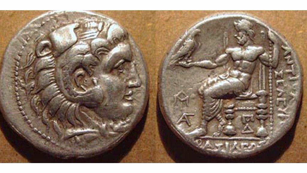 Coin issued by Selucus Nikator with Hercules wearing lion headdress on obverse and Zeus sitting on his throne holding an eagle on the reverse of the coin